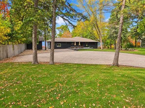 A residential property with a covered patio, a lawn, and trees with autumn foliage. -   Brainerd Waterfront Lake Retreat  Sleeps 18

 Hot Tub, Sand Beach, Great Fish (Brainerd)