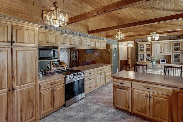 A spacious kitchen with wooden cabinets, a central island, and a built-in oven.