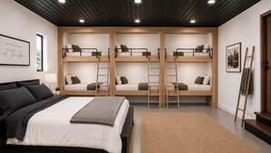 Ein Zimmer mit Etagenbett, Einzelbett und einer Leiter.