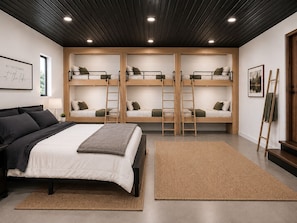 A room with a bunk bed, a single bed, and a ladder.