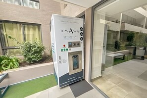 En automattankstation med en vattenkran, placerad utanför en byggnad med en glasdörr.