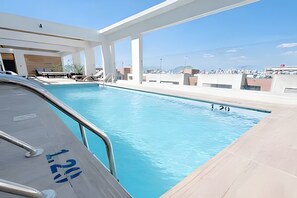 En pool på taket med fri utsikt över stadens silhuett.