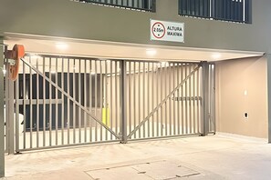 Ein begrenzter Eingangsbereich mit Durchfahrtshöhenbeschränkung, Metalltoren und einem Betonboden.