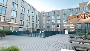A modern building with a courtyard featuring outdoor seating and umbrellas. - Contemporary, comfortable apartment with WiFi and air conditioning (Santiago)