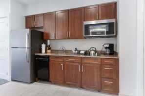 A kitchen with wooden cabinets, a stainless steel refrigerator, a microwave, and a coffee maker. - Gondola Right Outside - Westin Riverfront 2-Bedroom Villa (Avon)