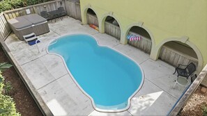 En swimmingpool med en uteplats, inklusive ett bord och stolar, samt en överbyggd sittplats.