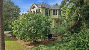 A large house with a wrap-around porch, surrounded by dense greenery and trees. - Ultra Classic | Private Pool, Hot Tub, and Community Pool (Corolla)