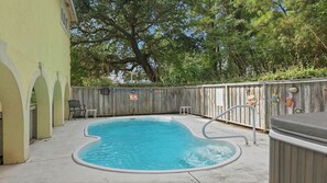 A swimming pool with a hot tub, surrounded by a wooden fence and trees. - Ultra Classic | Private Pool, Hot Tub, and Community Pool (Corolla)