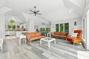 A spacious living area with a high ceiling, a ceiling fan, and a view of the kitchen. - Ultra Classic | Private Pool, Hot Tub, and Community Pool (Corolla)