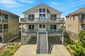 A two-story house with a balcony and a front porch. - Avalon Alibi | 300 ft to the beach | Private Pool, Hot Tub, and Pool Table (Kill Devil Hills)