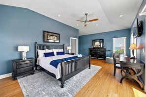 A bedroom with a bed, nightstands, a desk, and a chair. - Sea To Sound | 740 ft to the beach | Private Pool, Hot Tub, and Dog Friendly (Duck)
