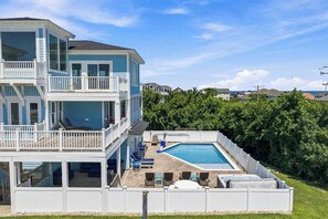 A multi-level residential building with a swimming pool, outdoor seating, and a fenced deck area. - Sea To Sound | 740 ft to the beach | Private Pool, Hot Tub, and Dog Friendly (Duck)