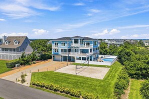 A multi-story house with a balcony, a swimming pool, and a well-maintained lawn. - Sea To Sound | 740 ft to the beach | Private Pool, Hot Tub, and Dog Friendly (Duck)