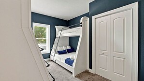 A bedroom with a bunk bed, a white door, and a window with blinds. - Sea To Sound | 740 ft to the beach | Private Pool, Hot Tub, and Dog Friendly (Duck)