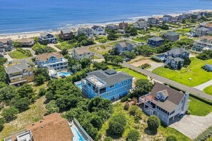 A residential area with houses, a swimming pool, and a beach in the background. - Sea To Sound | 740 ft to the beach | Private Pool, Hot Tub, and Dog Friendly (Duck)