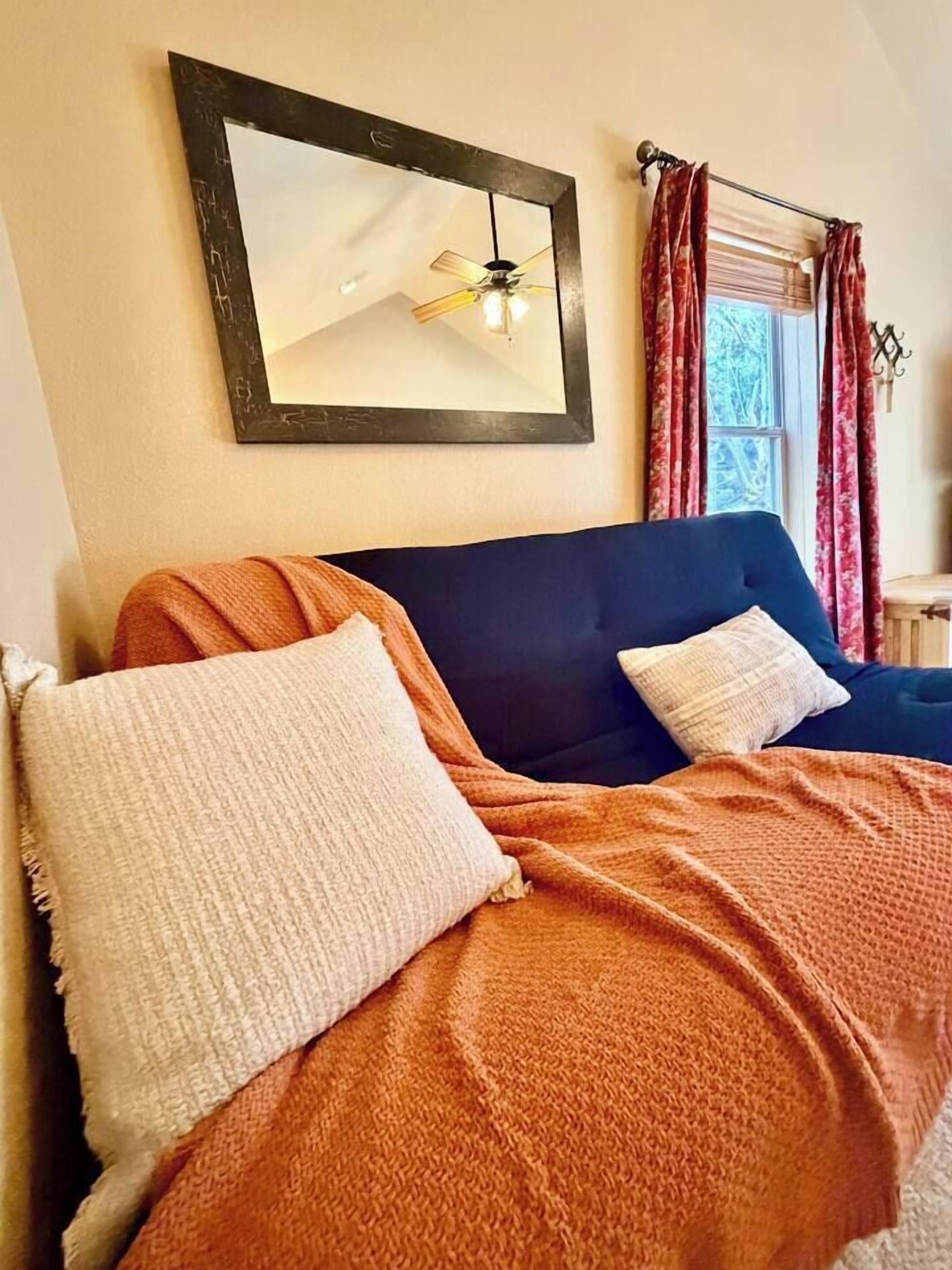 Un letto con una testiera scura, due cuscini e una coperta.