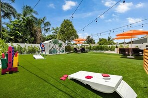 A well-maintained backyard with artificial grass, outdoor seating, and a children's play area. - Casa Palma | Pool | Outdoor Fun | Near Beaches (Fort Lauderdale)