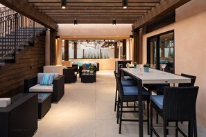 Eine Terrassenanlage im Freien mit Esstisch, Stühlen, Sofas und einer Treppe.