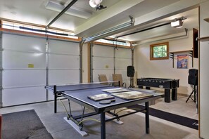 A room with a ping pong table, a foosball table, and a projector.