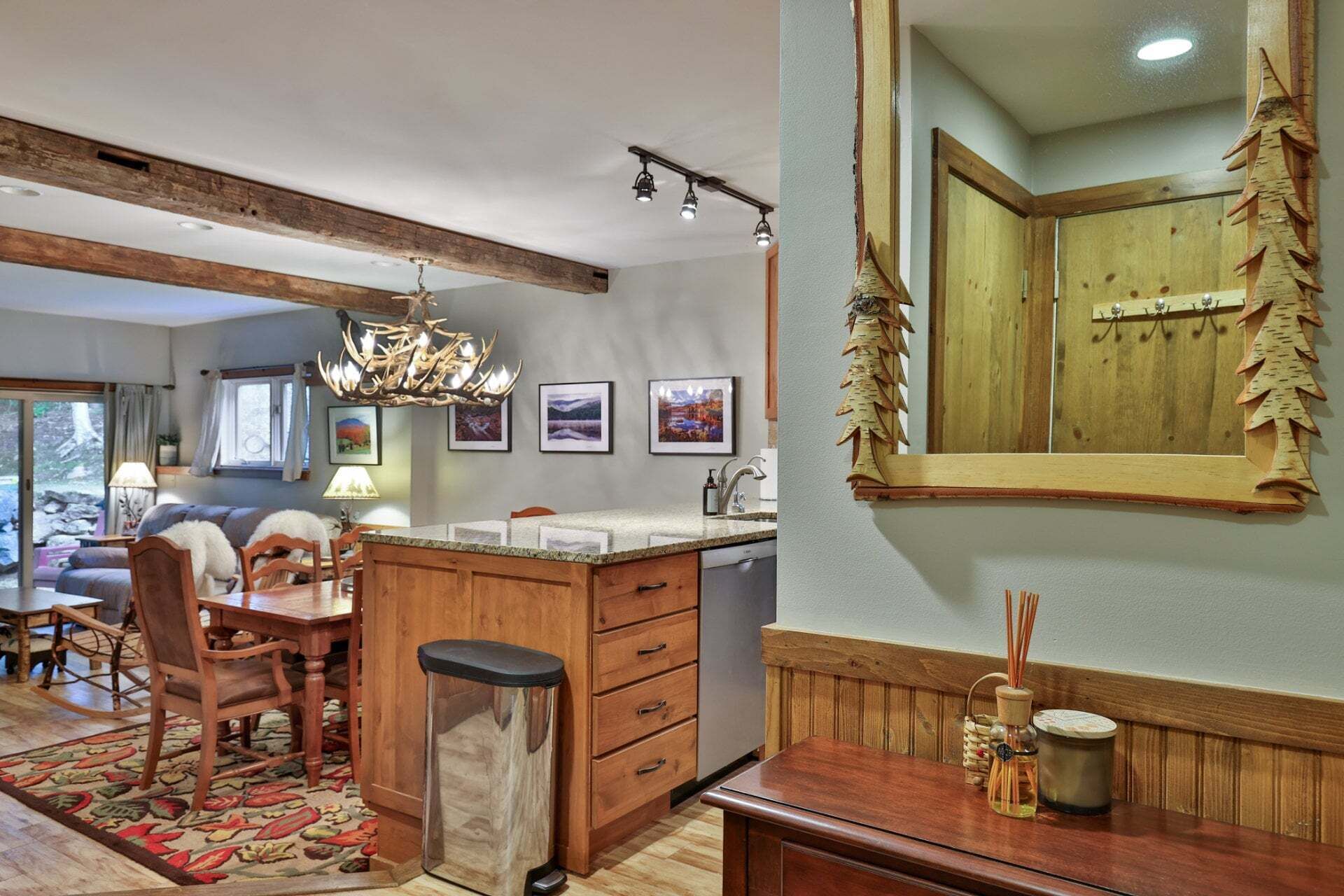 A kitchen with a wooden island, a chandelier, and a large mirror with a wooden frame.
