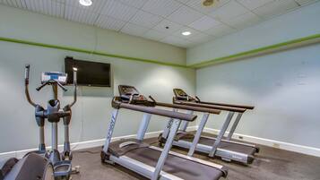 A gym with treadmills, a stationary bike, and a rowing machine.