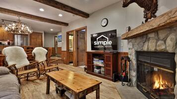 A rustic interior with a fireplace, wooden furniture, and a television displaying 'simple vacation rentals'.
