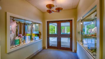 A hallway with a wooden ceiling, a double door, and glass display cases on either side.