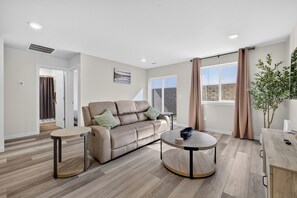 Una sala moderna con sofá, mesa de centro y vistas al exterior.