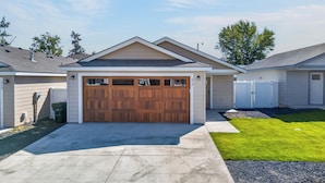 A residential house with a double garage, a front yard, and a white fence. - Proper Stay 2BD/2BA  Stanfield (Stanfield)