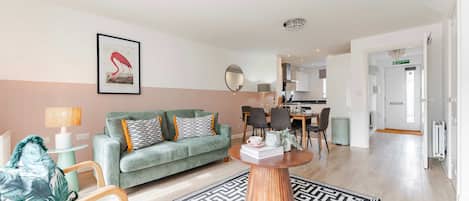 Una sala de estar moderna con un sofá, una mesa de centro y un comedor con sillas y una mesa.