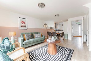 Ein modernes Wohnzimmer mit einer Couch, einem Couchtisch und einem Essbereich mit Stühlen und einem Tisch.