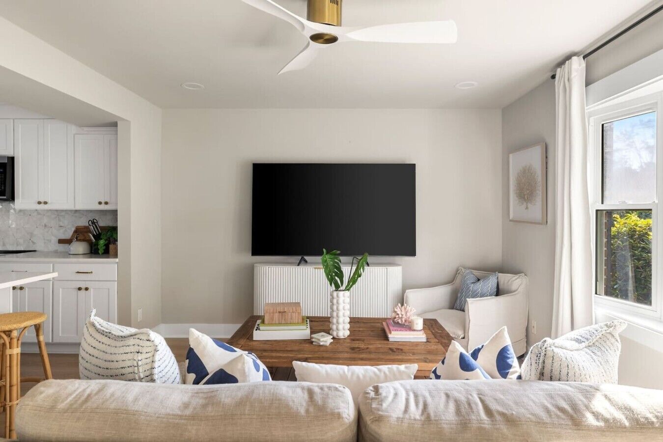 A modern living room with a flat-screen TV, a coffee table, and a sofa.