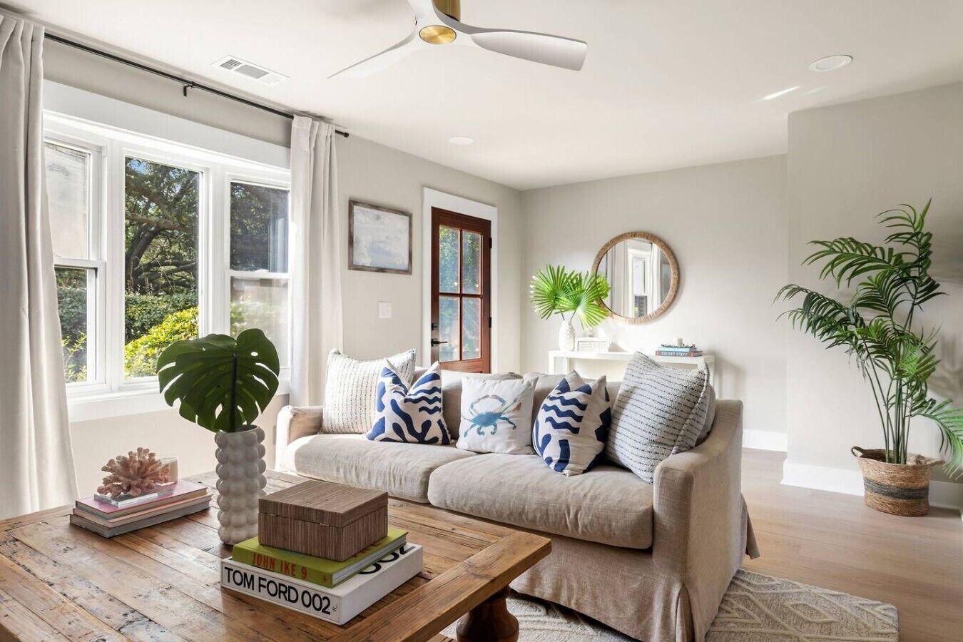 A living room with a sofa, coffee table, and a large window.