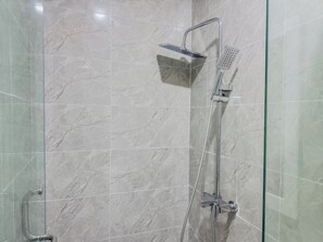 A modern bathroom with a glass shower enclosure, a handheld showerhead, and a wall-mounted control panel. - Special Studio Apartment in Victoria Island with Pool, Fast Wi-Fi & 24/7 Power (Lagos)