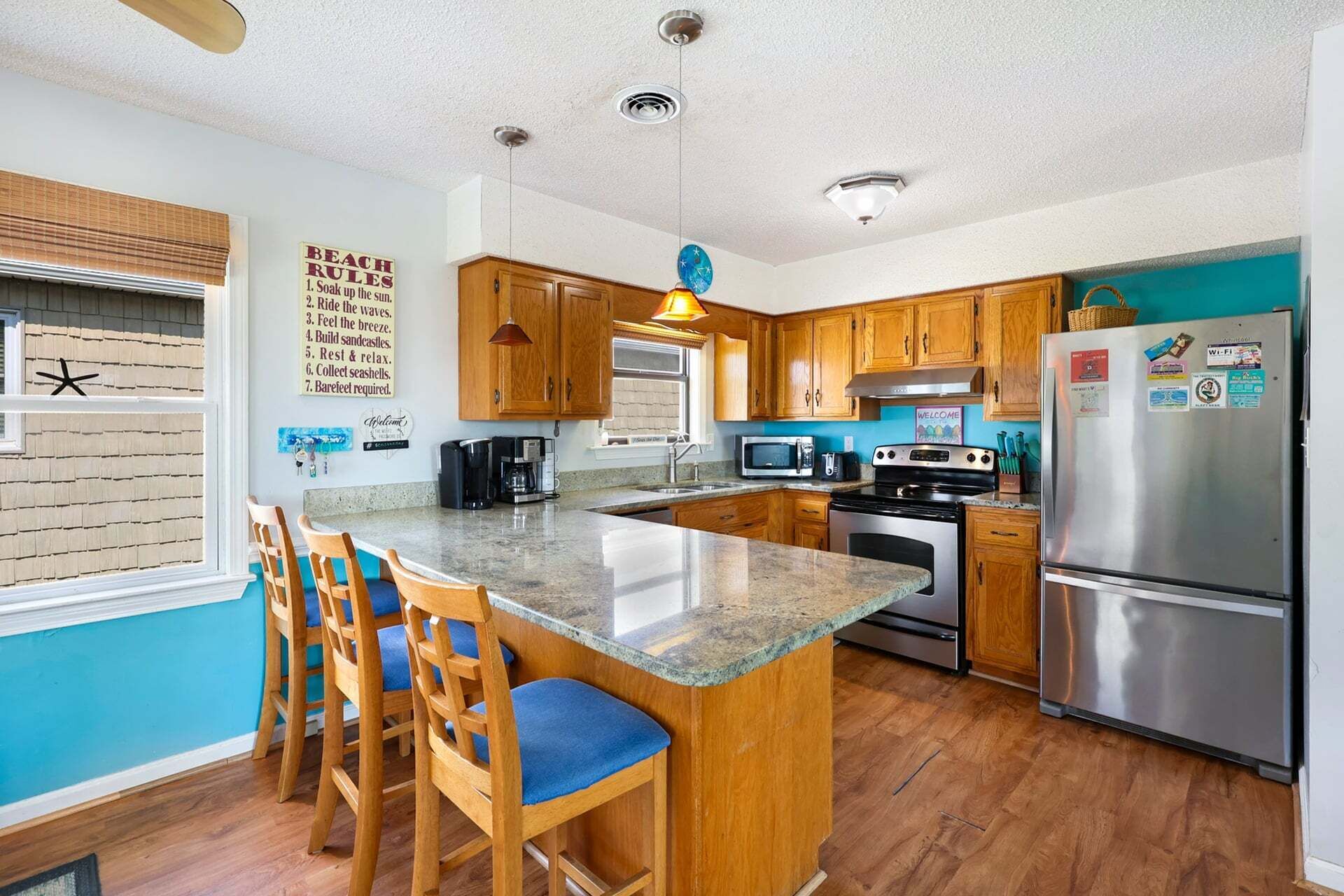 A kitchen with wooden cabinets, a stainless steel refrigerator, a microwave, and a coffee maker.