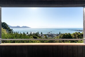 A view from a balcony overlooking a coastal area with mountains in the distance.