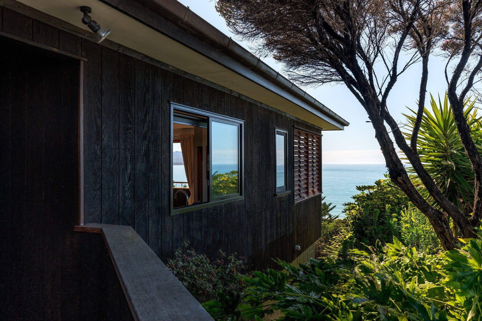 A modern building with large windows overlooking a body of water.