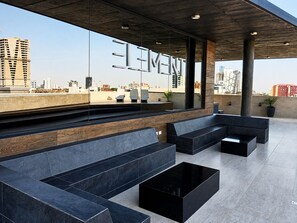 Un área de estar al aire libre moderna con bancos escalonados y vista a la ciudad.