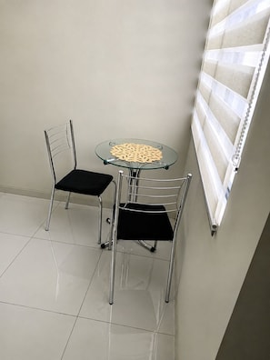 A small room with two chairs and a glass table.