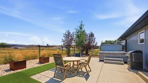 A patio with a table and chairs, a barbecue grill, and a view of a field. - The Perfect Pace by Park City Vacations (Park City)