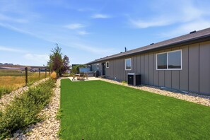 A residential property with a well-maintained lawn, outdoor furniture, and a large window. - The Perfect Pace by Park City Vacations (Park City)