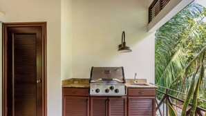 Una cocina con estufa a gas, un lavamanos y una puerta.