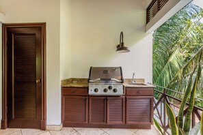 A kitchen with a gas stove, a sink, and a door. - 6 Bdr Penthouse with Plunge Pool and Beach Club Access! (Tamarindo)