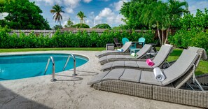 A poolside area with lounge chairs and a pool.