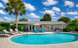 A swimming pool with lounge chairs and a covered seating area. - Sunshine on Crestdale - 3/2 Pool home Sleeps 8 (Palm Beach Gardens)