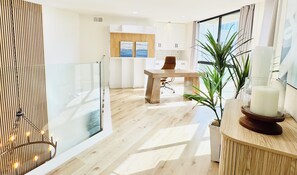 Ein modernes Interieur mit Holzboden, einem Esstisch, Stühlen, einem Blumentopf und einer Vitrine mit einer Kerze.