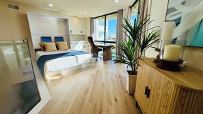 Ein modernes Hotelzimmer mit einem Bett, einem Schreibtisch und einem großen Fenster.