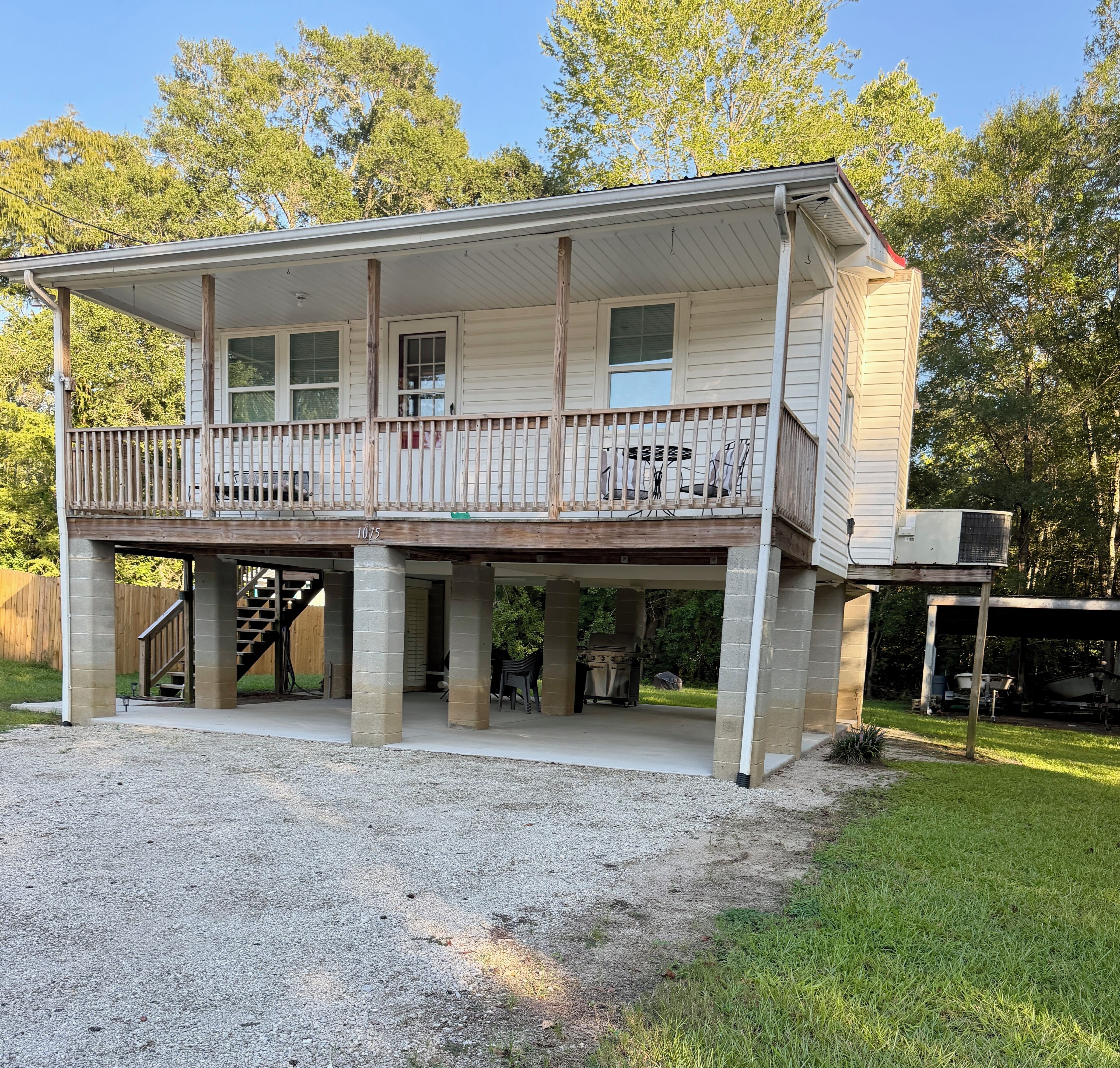 A two-story house with a covered porch and a deck.