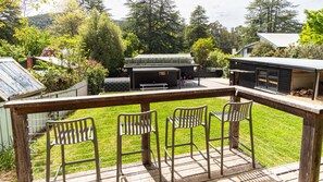 A deck with metal chairs and a barbecue area. - Stoke and Steam - the ultimate pad for adventurers (Bright)