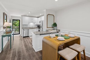 Eine moderne Küche mit weißen Schränken, einer Granitabdeckung und einem eingebauten Kühlschrank.
